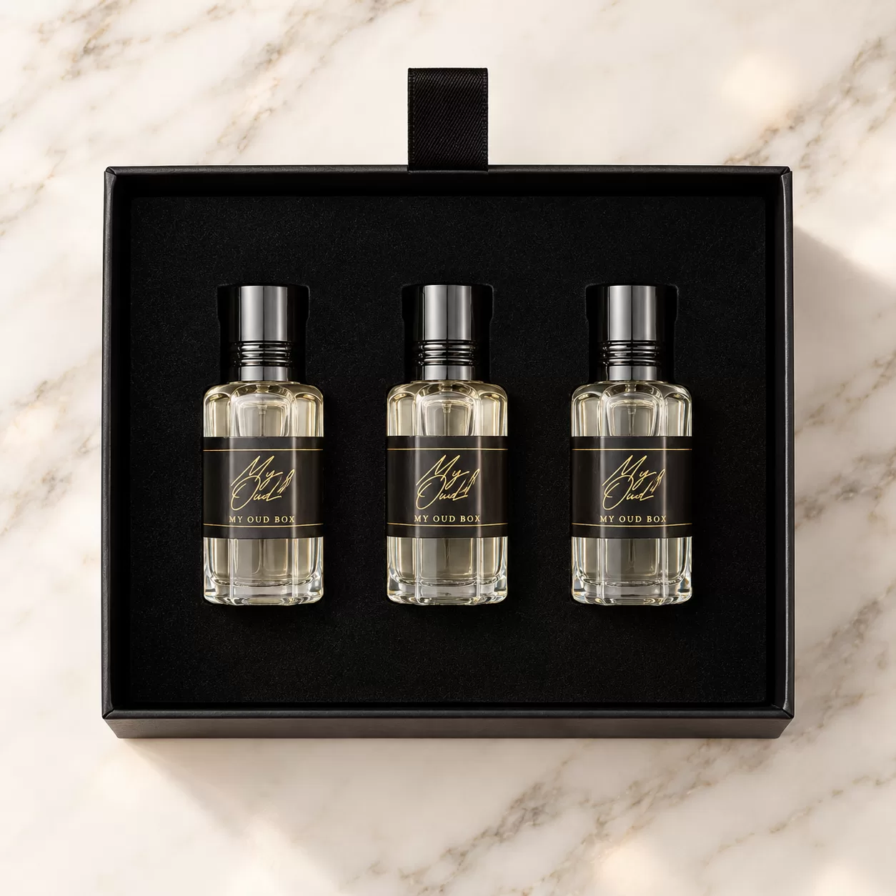 Three My Oud Luxury Oil bottles arranged inside an open black presentation box.